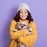 female hugging her puppy looking directly camera with satisfied facial expression 1