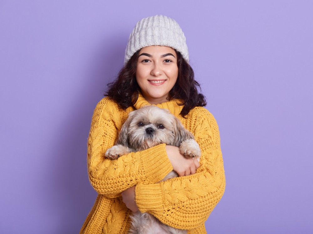 female hugging her puppy looking directly camera with satisfied facial expression 1