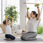full shot adult kid holding dumbbells